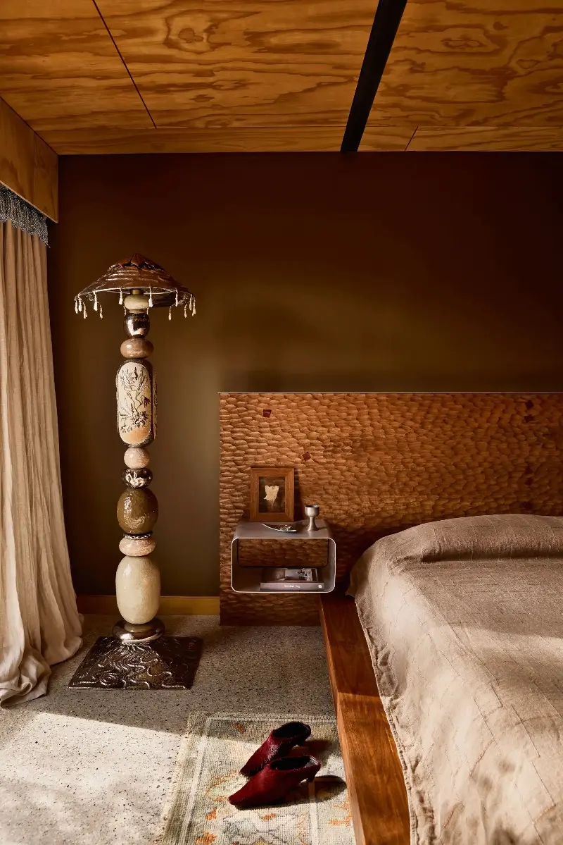 The main bedroom features a Murano pendant (not shown) hanging above one bedside table and a floor lamp next to the other. 