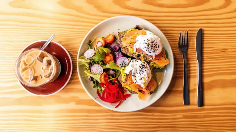 Avocado toast with salmon and poached egg for breakfast, table top view