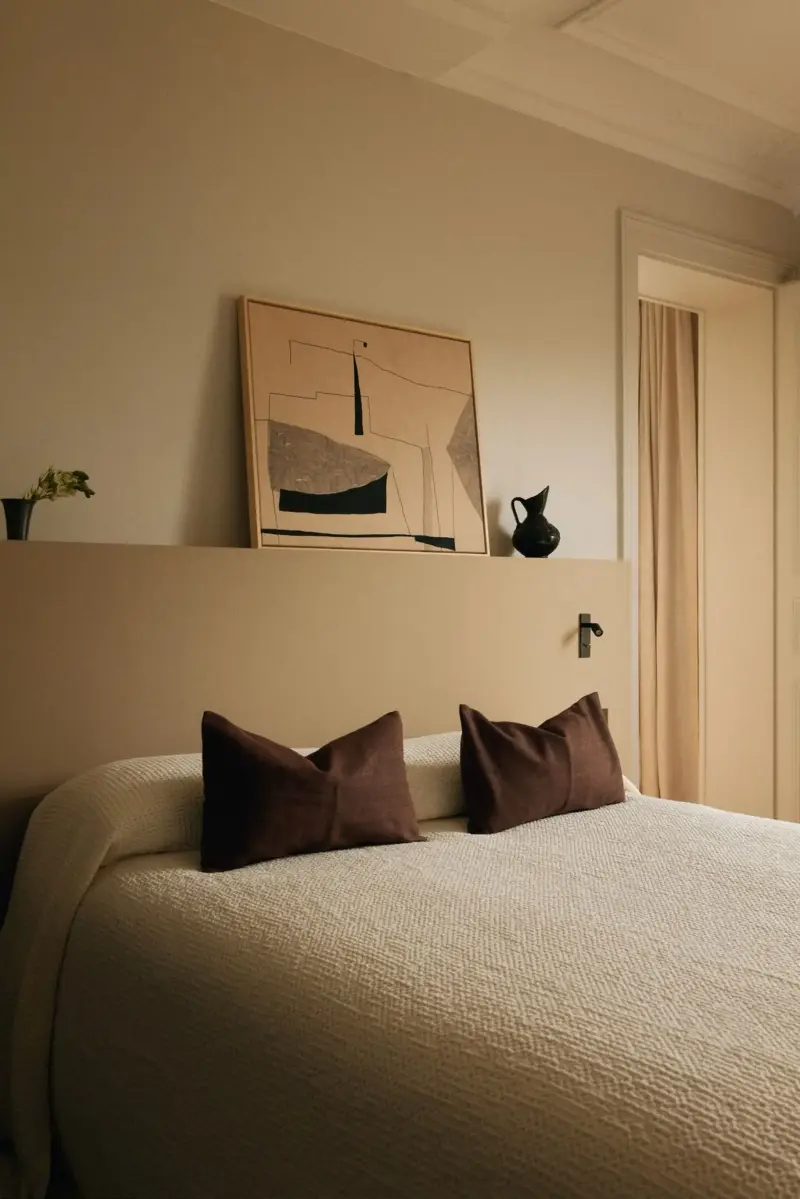 Farrow & Ball’s London Stone No. 6 highlights the headboard wall, with School House White No. 291 on the surrounding walls. The painting by Anita Geins and the vintage Mexican stoneware pitcher add a collected feel.Design: Diettert Collet, Photography: Clément Gérard