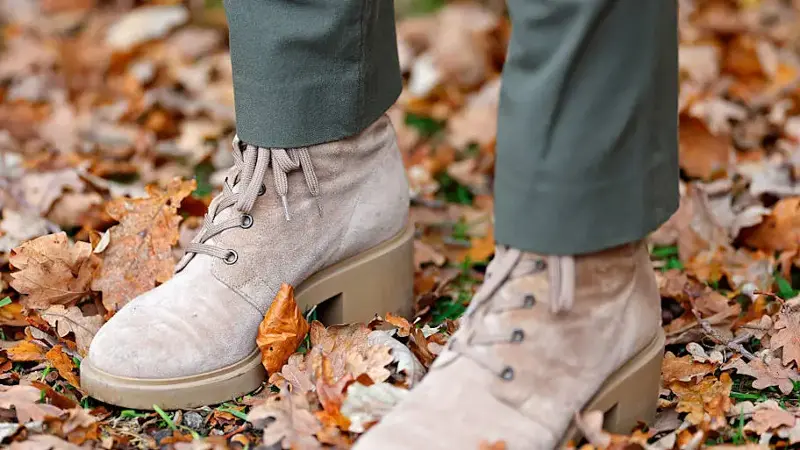 A person walks through fallen leaves