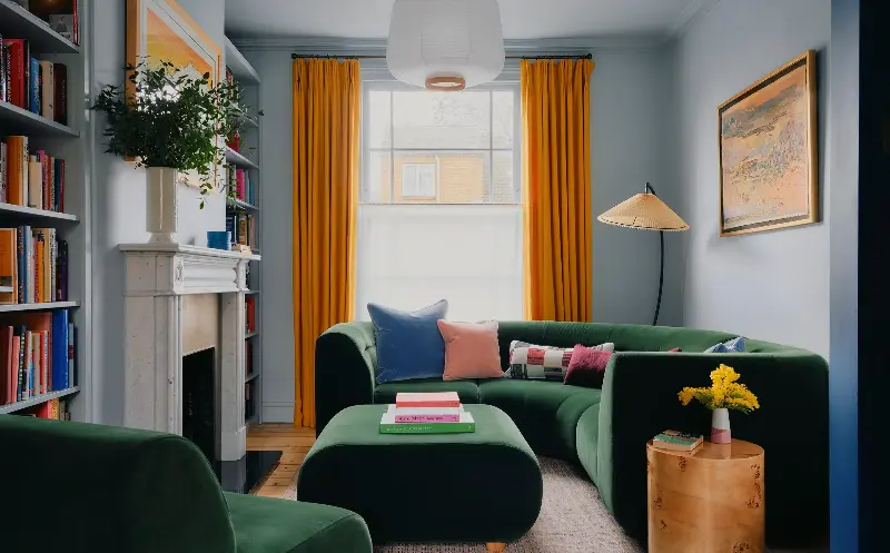 The orange-and-blue look in this room is meant to evoke the sun, with the green furniture adding a touch of the outdoors