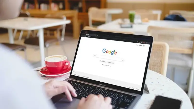 Person about to search for something on Google in a cafe