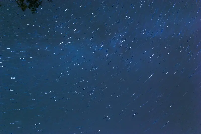 Captivating long exposure of star trails forming a swirling pattern in the night sky.