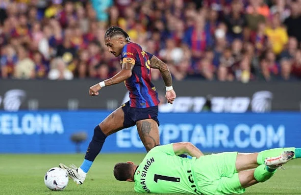 Raphinha dribbles past goalkeeper Unai Simons. Photo: Getty.