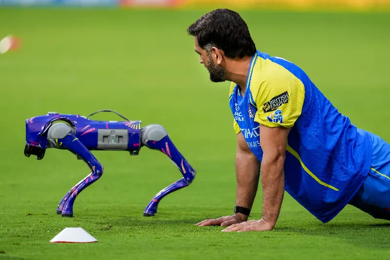 CSK's MS Dhoni with a robotic camera dog during a practice session.