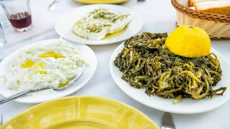 Horta wild greens, tzatziki olive oil, feta kathoura Ikarian cheese food at restaurant on Ikaria island, Greece longevity blue zone diet