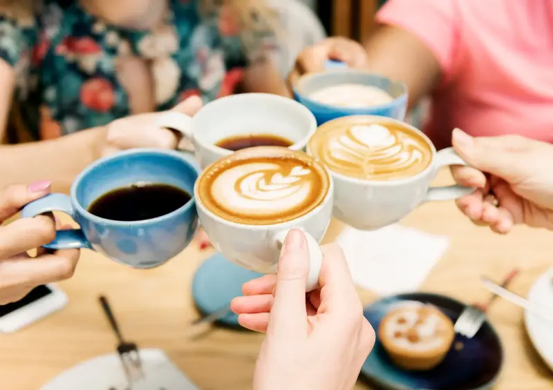 A stock image shows a group of friends having coffee together.