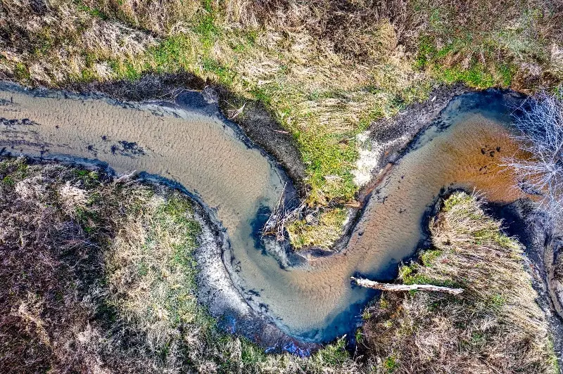 Aerial view of a meandering river bend through a grassy Minnesota landscape