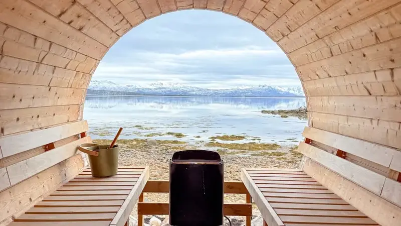 Scenic Fjord View from Inside a Wooden Sauna with Minimalist Benches