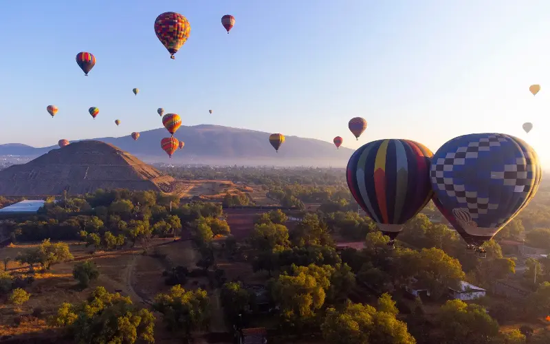 Hot-air balloons fly over the majestic Teotihuacán at sunrise - al_la/iStockphoto