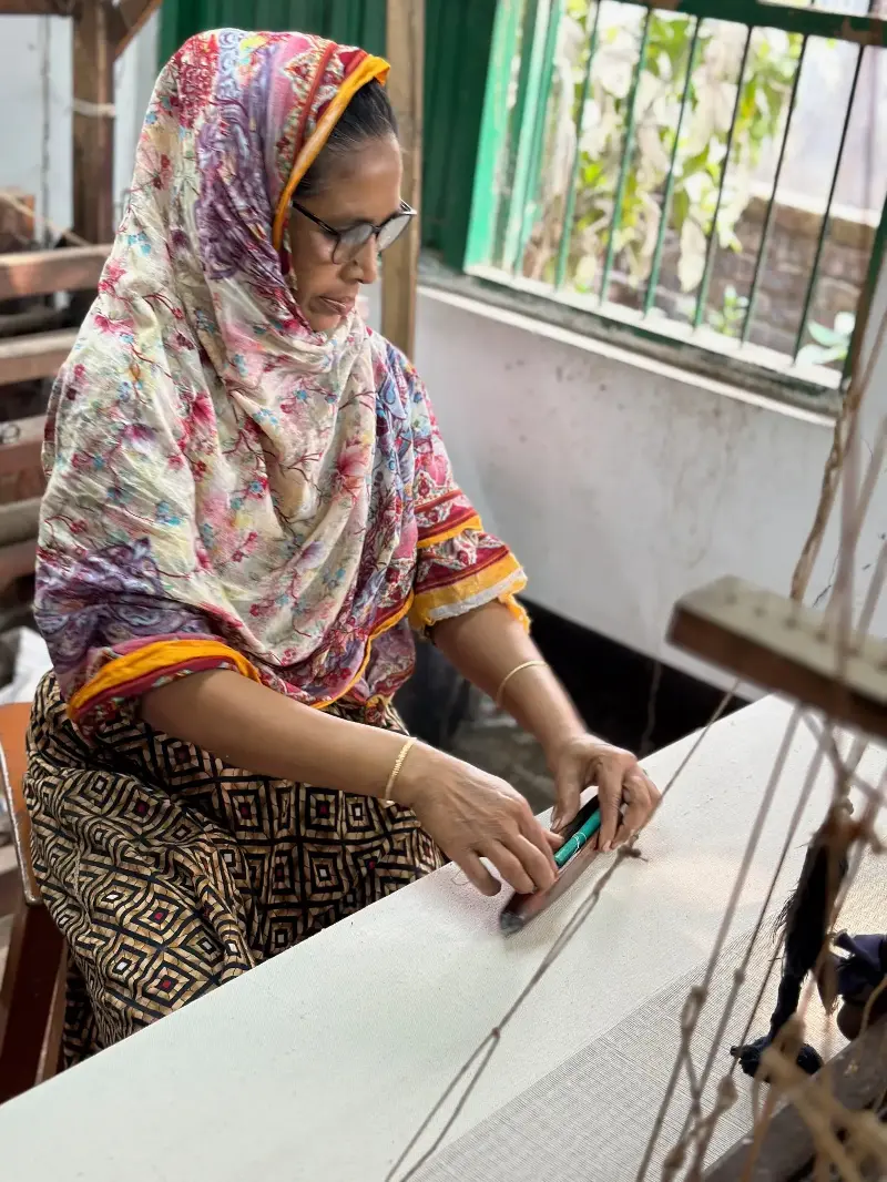 A weaver at Swallows in Bangladesh creates fabric for Indilisi, preserving traditional hand skills while supporting lower-impact production and dignified livelihoods (Safia Minney)