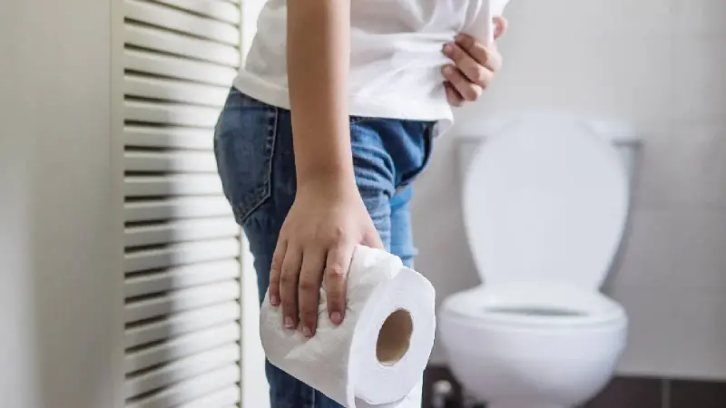 A woman holding a toilet paper roll in the bathroom