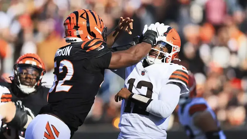 Shedeur Sanders passes under pressure from Cincinnati Bengals defensive end Cedric Johnson.
