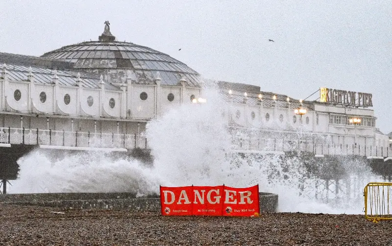 ... as waves crash in by the Palace Pier in nearby Brighton - Alamy Live News/Simon Dack News