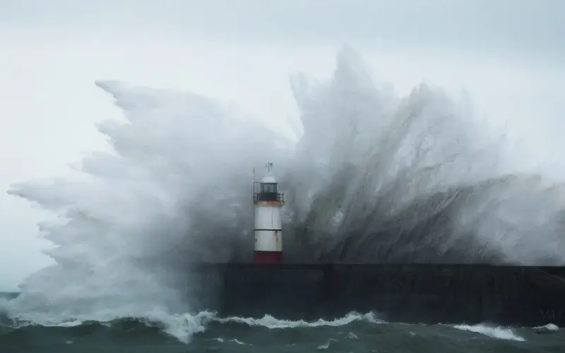 Waves crash over the lighthouse at Newhaven Harbour, East Sussex, during Storm Austen - REUTERS/Toby Melville