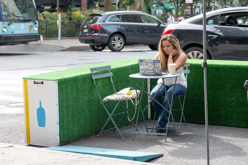 NEW YORK, NEW YORK - SEPTEMBER 09: A woman wearing a mask works on her laptop at Blue Bottle's outdoor seating as the city continues Phase 4 of re-opening following restrictions imposed to slow the spread of coronavirus on September 09, 2020 in New York City. The fourth phase allows outdoor arts and entertainment, sporting events without fans and media production. (Photo by Alexi Rosenfeld/Getty Images)