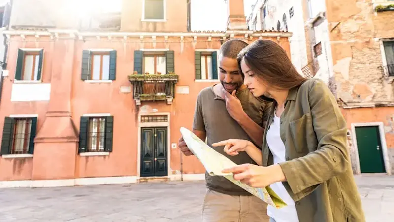 Italy, Venice, young couple looking at map in the city