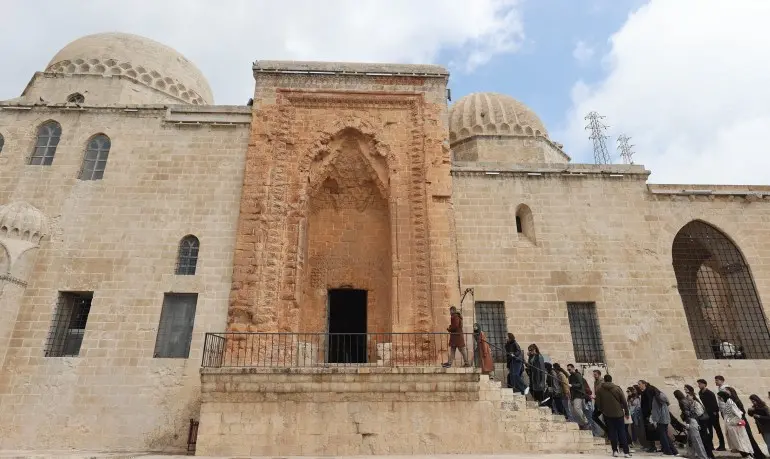 أُعيد افتتاح المدرسة القاسمية التاريخية في مدينة ماردين جنوب شرقي تركيا كمركز للتعليم، بعد انقطاع دام نحو قرن، وفق ما يظهر في لقطة جوية للبلدة القديمة. وتُعد المدرسة، التي خرّجت آلاف العلماء على مدى نحو 520 عامًا، من أبرز المعالم التعليمية في المنطقة، حيث تستضيف حاليًا دروسًا لمرحلتي البكالوريوس والدراسات العليا خمسة أيام في الأسبوع، داخل خمسة صفوف دراسية مخصصة لطلاب جامعة ماردين آرتقلو. ( Halil İbrahim Sincar - وكالة الأناضول )