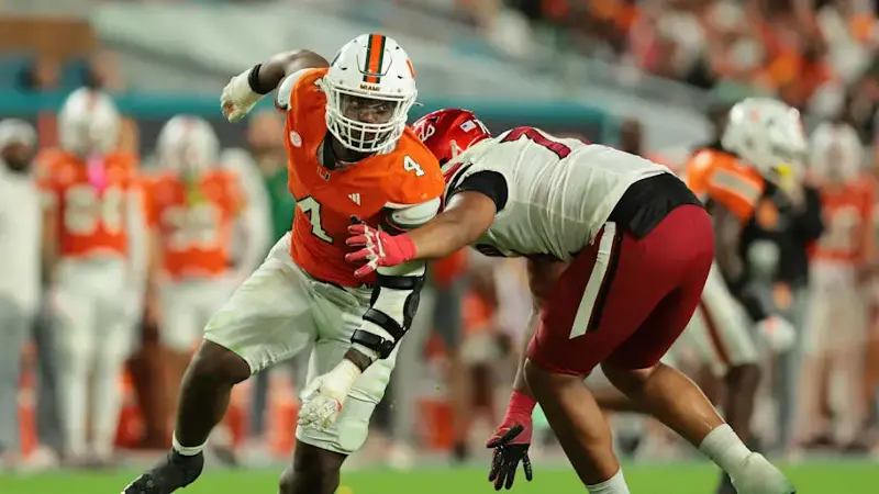 Rueben Bain Jr. escapes Louisville offensive lineman Trevonte Sylvester during the third quarter at Hard Rock Stadium.
