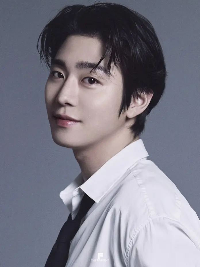 Ahn Hyo-seop with black hair, wearing a white shirt and black tie, set against a gray background.