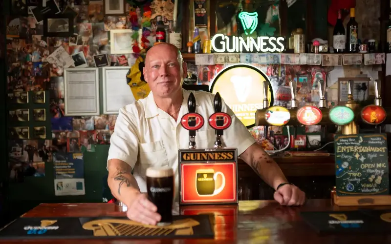 Landlord Aidan Mahon behind the bar of Pogue Mahon’s in Norwich, a ‘multifaceted business offering much more than just alcohol’ - David Rose