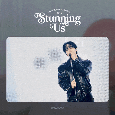 A male singer performing on stage, wearing a black leather jacket, holding a microphone, with bright stage lights in the background. The text above reads 'Lee Junho Fan Meeting 2026 Stunning Us'.