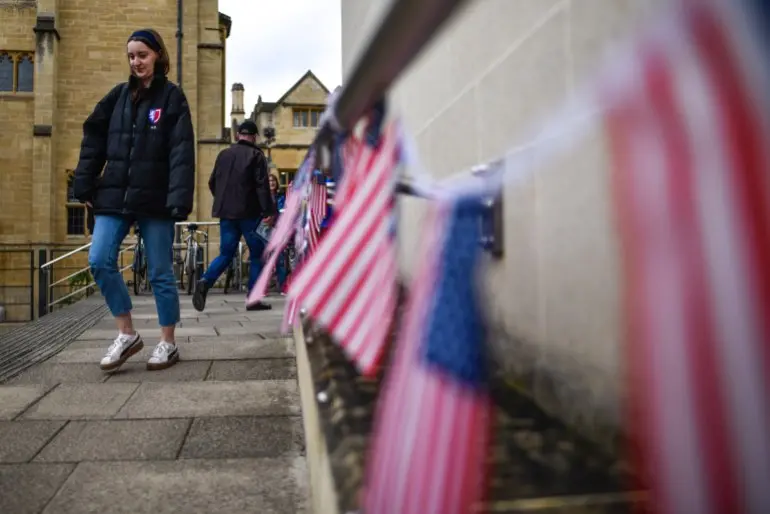 OXFORD, ENGLAND - MARCH 03: A woman walks past American flags outside a polling station on Super Tuesday on March 3, 2020 in Oxford, England. 1,357 Democratic delegates are at stake as voters cast their ballots in 14 states and American Samoa on what is known as Super Tuesday. (Photo by Peter Summers/Getty Images)