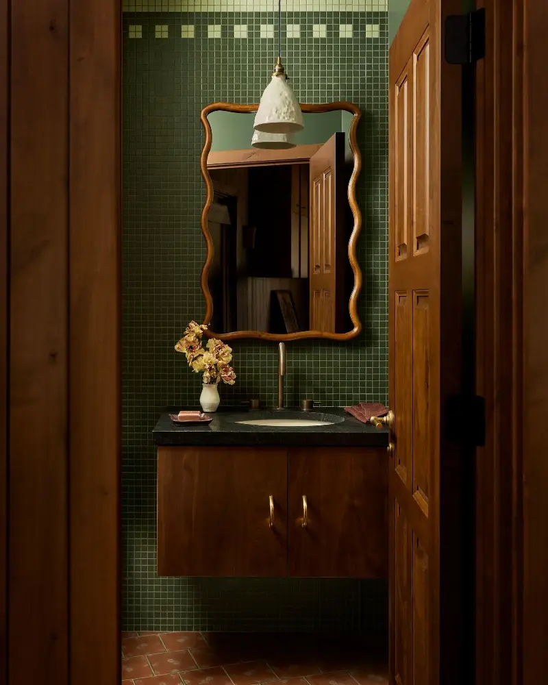 Smooth curves are punctuated by clean lines in this powder room, which cohesively connects to the deep green tones in the bedrooms.Malissa Mabey. Design: Susannah Holmberg Studios. Styling: Jen Paul