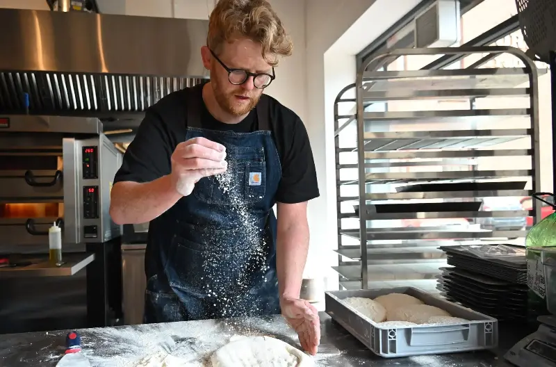 Peter Thomson, owner of Flout!, makes pizza dough in his first retail outlet in Portview Trade Centre in East Belfast in 2022.