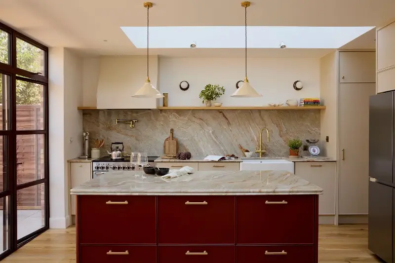 The warm tones of the Nacorado quartzite, finished with a double bullnose edge, work perfectly alongside the kitchen island painted in Little Greene's Bronze Red.  (Image credit: Design: Den Photography: Kristy Noble )