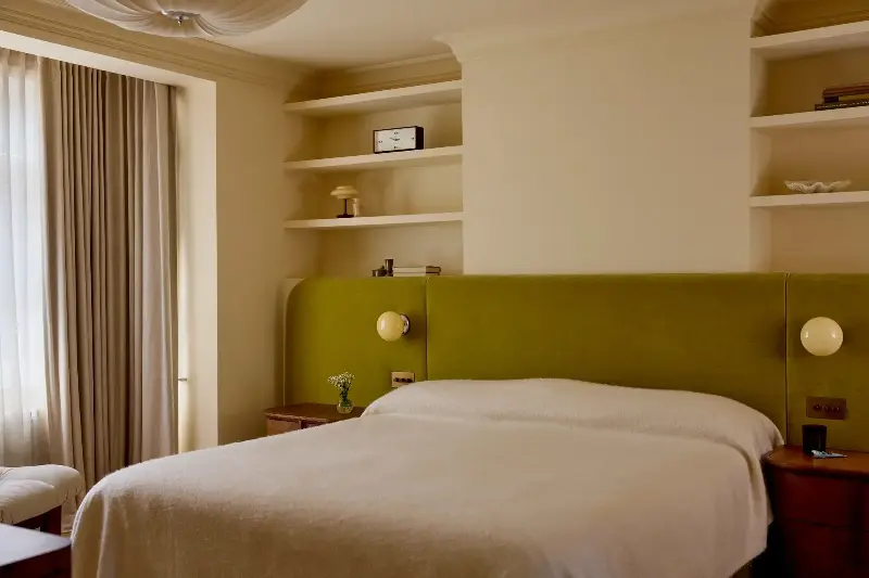 A luxurious, bespoke headboard, with Zara Home's Glass and Metal Wall Lights and Soho Home's Avery Bedside Tables. (Image credit: Design: Den Photography: Kristy Noble )