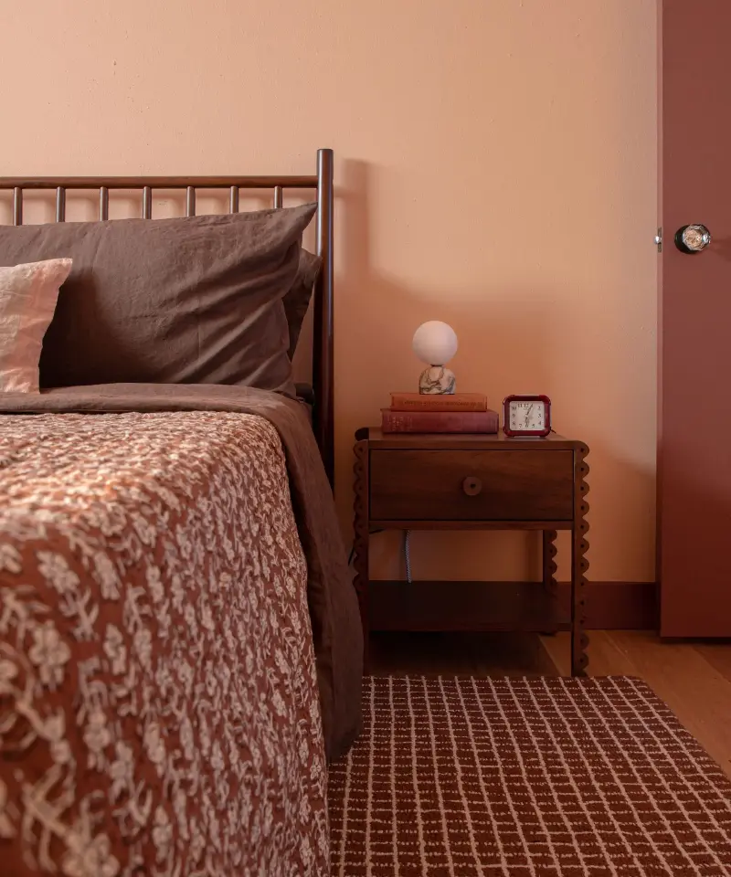 Sucher Studios treats peachy pink as a warm neutral, repeating its earthy undertones through the timber, linen and rust-colored pattern. (Image credit: Sucher Studios)