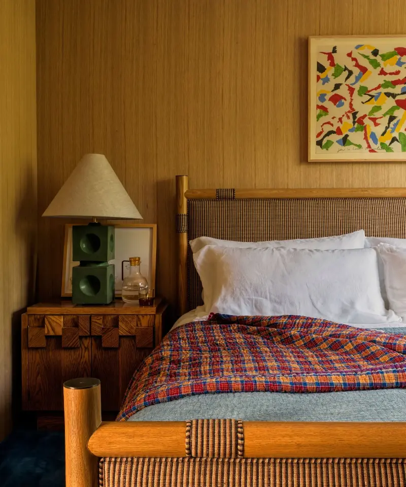 The white-oak paneling shifts through honey, tan and brown as the light changes, giving this bedroom a tonal depth flat paint could not replicate. (Image credit: Freudenberger Design Studio)