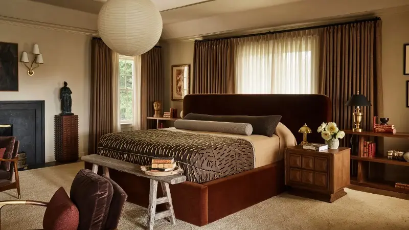Plaster & Patina repeats closely related stone, tobacco, rust and wood tones across the room, limiting sharper contrasts to smaller details so the eye travels easily. (Image credit: Plaster & Patina)