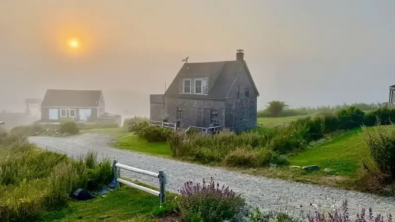 Sunset over small houses and flowers, Monhegan island, Maine
