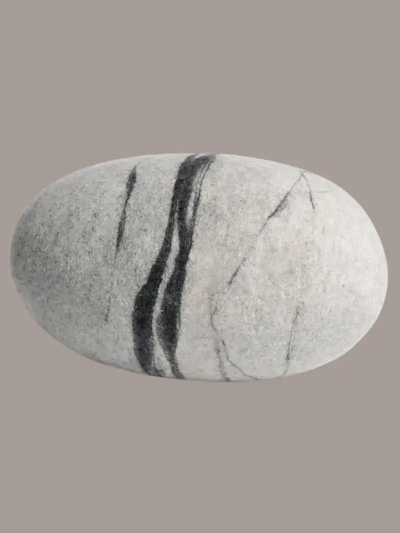 A felted wool stone pillow from Sandal Felt on Etsy