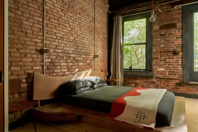 This custom oak bed with its extended headboard and landing zones might be one of my favorite details in this rightfully barebones bedroom. (Image credit: Seth Caplan. Design: New Operations Workshop. Styling: Logan Sommers)