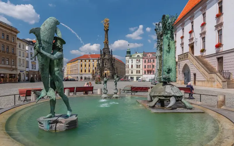 The Holy Trinity Column, pictured across the square from the fountain, sits at the heart of Olomouc - Gistel Cezary Wojtkowski/iStock Editorial