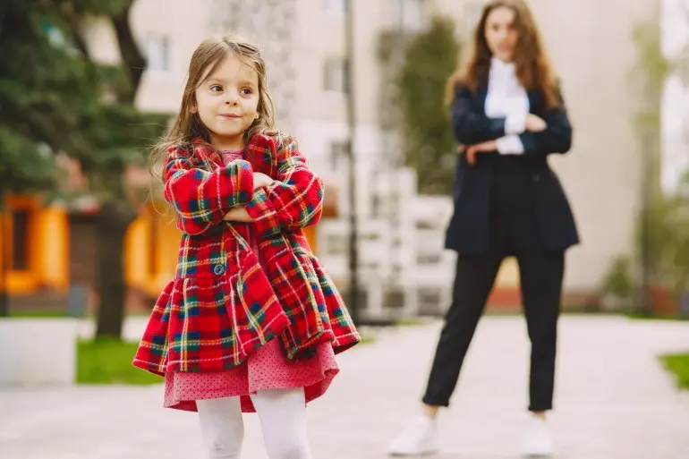 Fashionable mother with daughter. Family in a spring city. Woman in a black suit.
