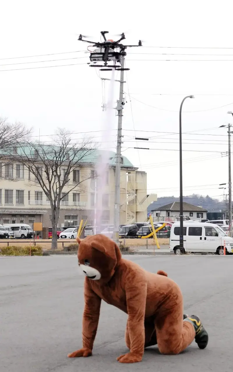 Bear spray containing capsaicin is sprinkled from a drone toward a staff member wearing a bear costume during a demonstration - Getty Images