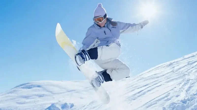 Girl (15-17) snowboarding, low angle view, Sun Valley Idaho, USA