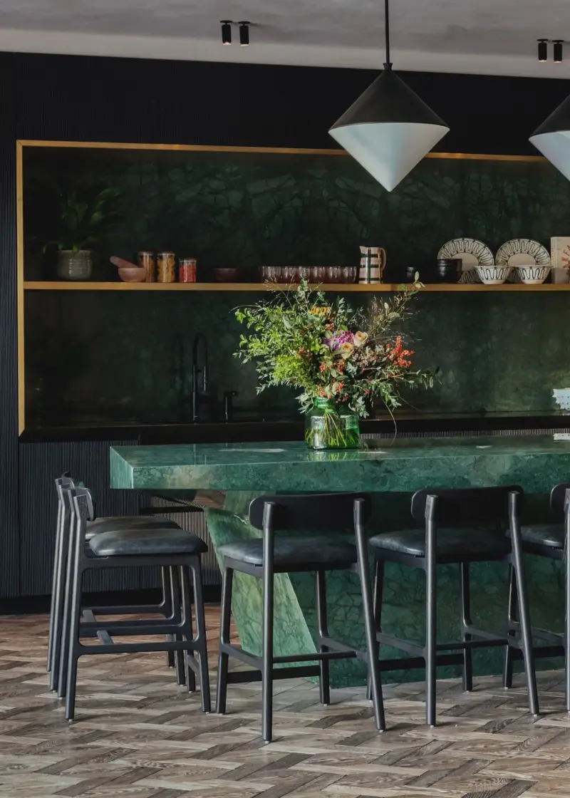 Studio Duggan doubles down on green stone, taking it from backsplash to island. (Image credit: Mariell Lind Hansen. Design: Studio Duggan)