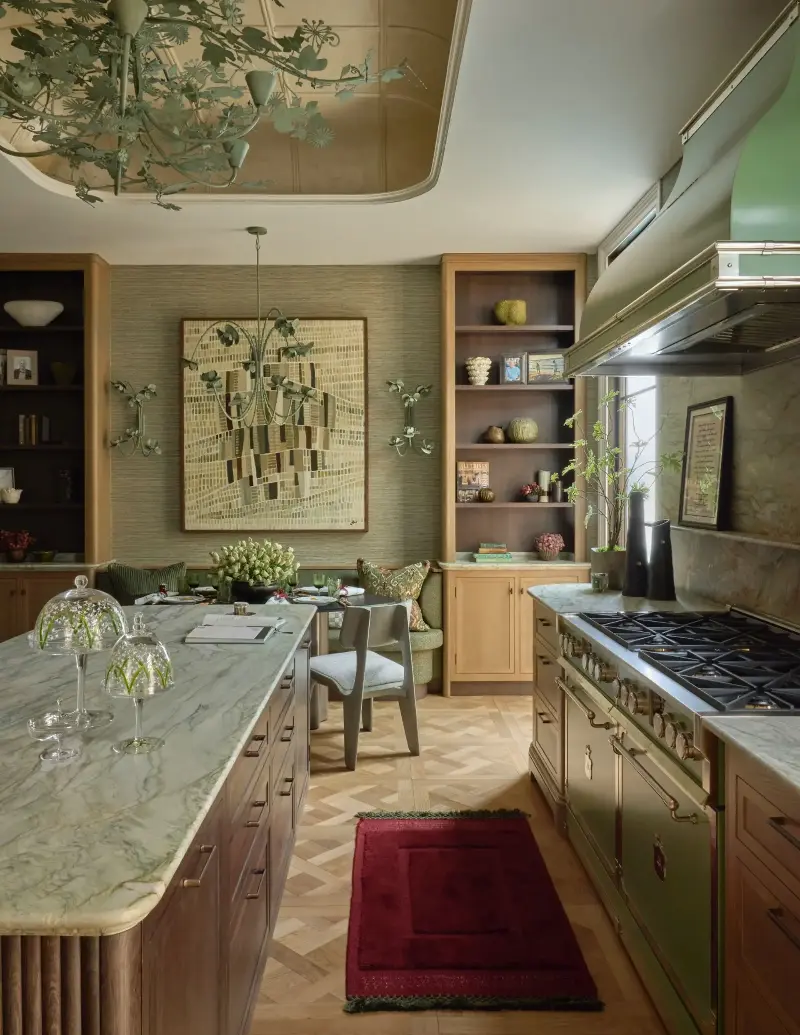Samantha Bartlett layers green through stone, lighting, and appliances, with red accents adding a sharp counterpoint. (Image credit: James McDonald. Design: Samantha Bartlett / Martin Moore)