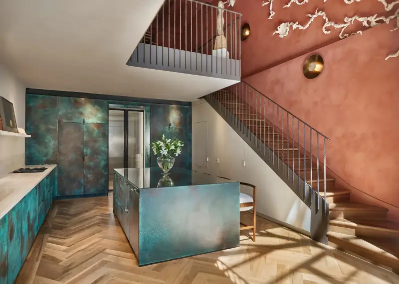 Verdigris copper washes the cabinetry in sea-green, turquoise and rusty tones that shift with the light. (Image credit: Photo credit: Ledbury Studio)