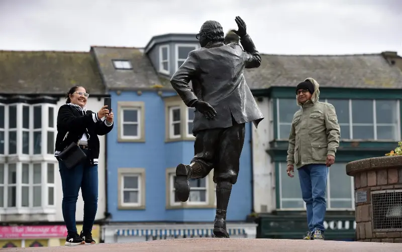Visitors admire the sculpture of Morecambe-born comedian Eric Morecambe - Asadour Guzelian