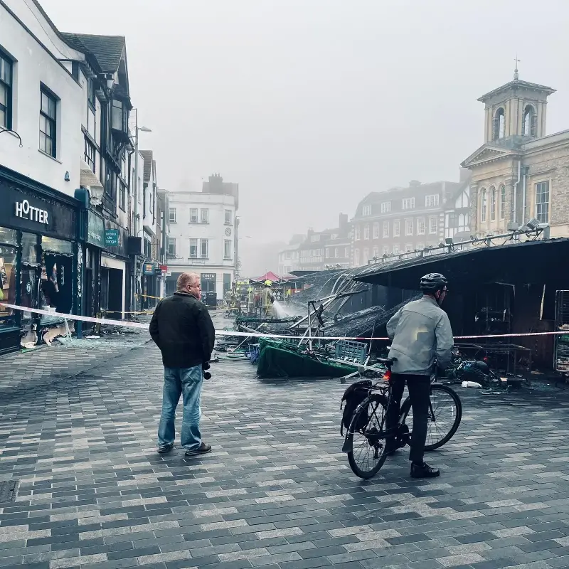 Passers-by look at the damage caused by the fire in Kingston’s Ancient Market Place (JR)