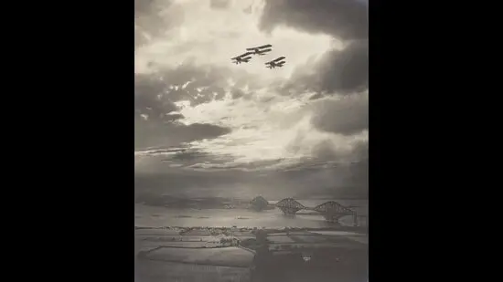 Scotland’s Forth Bridge spans a slender river, with its three magnificent steel arches in clear but minute view, in an image from 1918. (Galleries of Scotland; Richard and John Buckham)