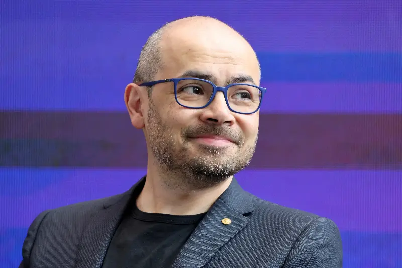 Demis Hassabis listens during a debate at an AI summit at Imperial College London.